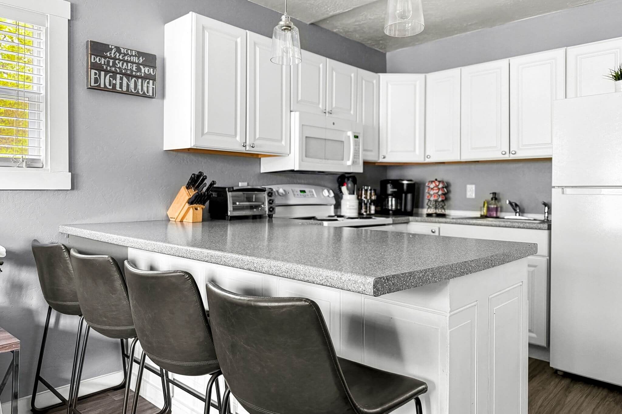 Bright and open kitchen bar with seating for four, perfect for enjoying meals or coffee at our Great Falls vacation rental. A great space for families or couples to relax.